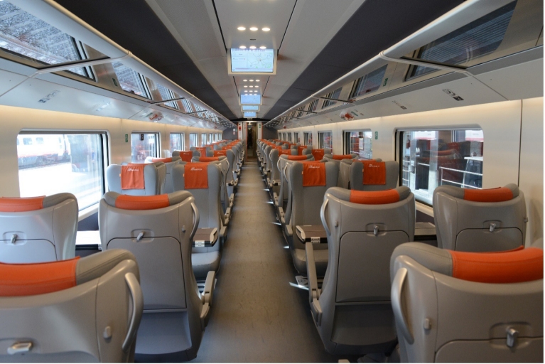 Scomparto bagagli e schermi TV in un treno Le Frecce